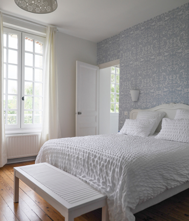 Slaapkamer met renovlies behang in zachte tinten en natuurlijk licht